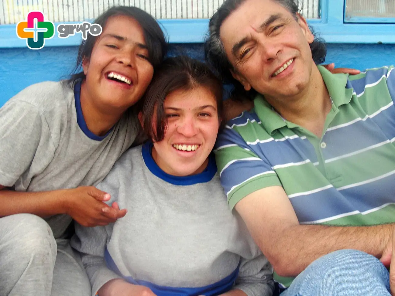 Tres personas abrazadas y sonriendo durante la jornada