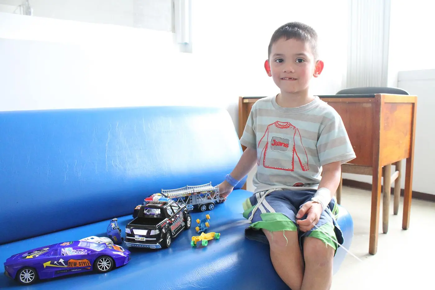 Niño junto a varios carros de juguete