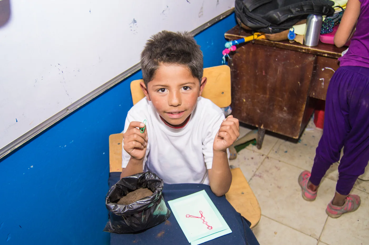 Niño recibe materiales durante una jornada en Quiba