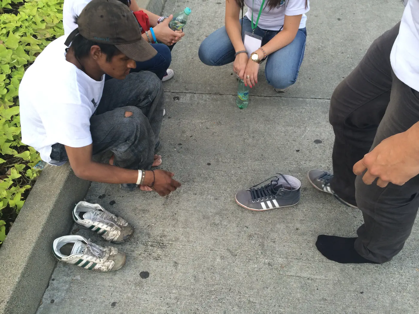 Persona en la calle junto a varios pares de zapatos durante Soluciones Juveniles 2014